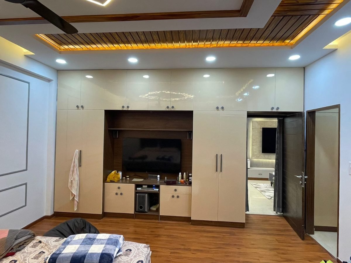 Living room TV unit with glossy storage and a wooden slatted false ceiling